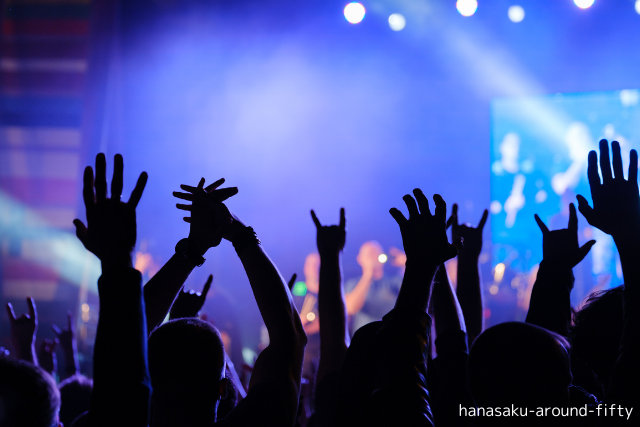 50代女性が推し活ライブを楽しむ光景。まばゆいステージと、心を整える静かなひととき
