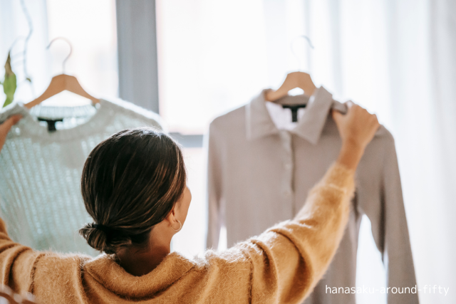 クローゼットの前で洋服を選ぶ女性。無料に振り回されず、本当に必要なものを選ぶ暮らしのイメージ